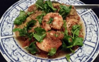 Pasta serving bowl of shrimp divolo garnished with flat leaf parsely