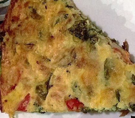 Slice of frittata on a paper plate viewed from above