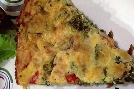 Slice of frittata on a paper plate viewed from above
