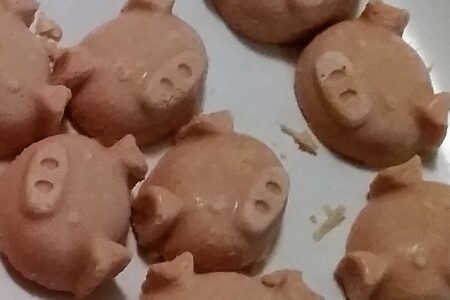 Close up of fat bombs extracted from ice trays, pig face shaped