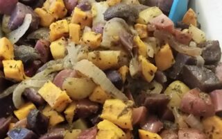 Finished four potato salad in white serving dish and tongs