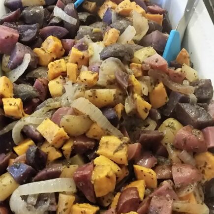 Finished four potato salad in white serving dish and tongs